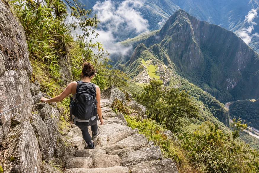 Hiker carefully using the steep stone stairs on Huayna Picchu