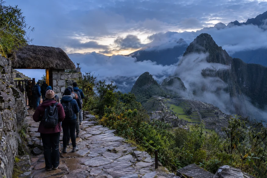 Travelers arriving at Machu Picchu in cool early morning mist