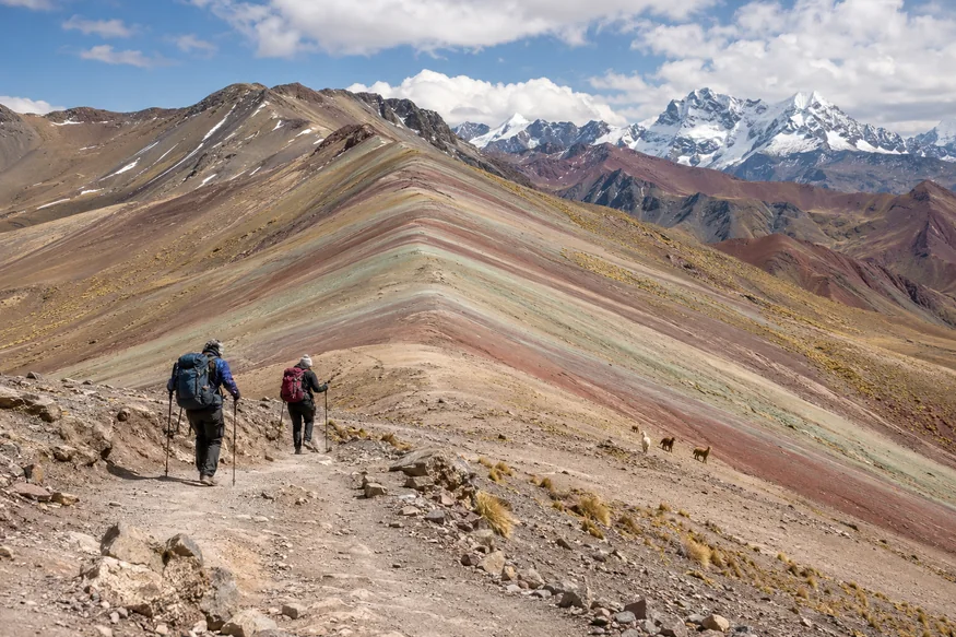 Hikers approaching Rainbow Mountain on a high-altitude Andean trail