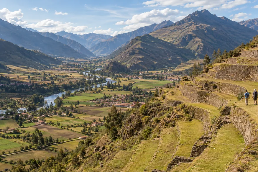 Travelers walking beside Inca terraces overlooking the Sacred Valley
